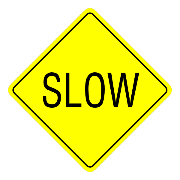 The image shows a yellow diamond sign with black text that reads "SLOW" on both sides of it against a dark background.