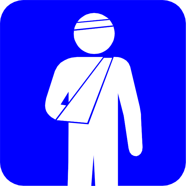 The image shows a blue sign with white text that reads "First Aid" accompanied by an icon of a person wearing a bandage on their arm next to a cross symbolizing medical assistance in case of emergency, and below it is another figure holding what appears to be a first aid kit or supplies.