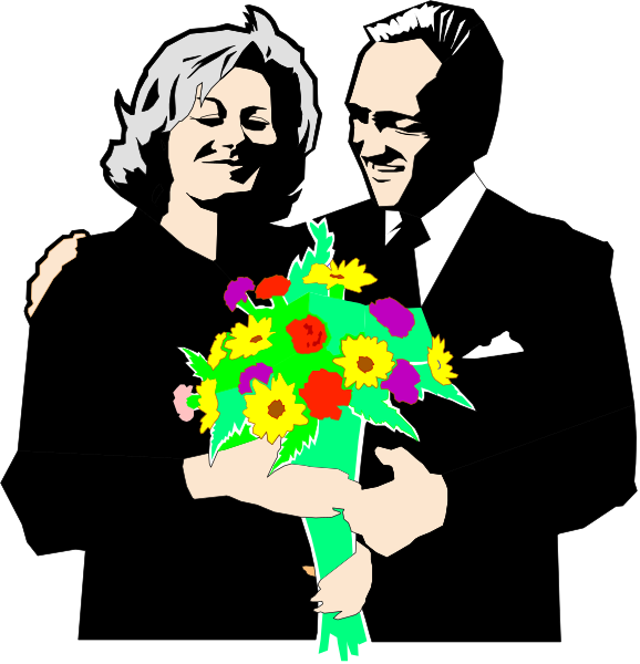 The image shows a man holding flowers with both hands while standing next to an older woman who is smiling at him; he appears surprised as if caught off guard by her attention.