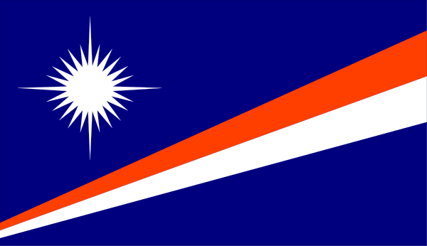 The image shows a flag with red stripes on top of an orange background at nighttime against a dark sky.