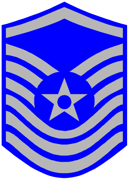 The image shows a blue shield with white stars inside it on top of an emblem that resembles a badge design featuring stripes in shades of gray and red around its perimeter; there is also a small star atop this central symbol, which appears to be part of the same insignia.