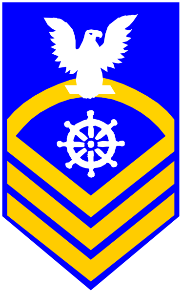 The image shows a blue shield with an eagle emblem on top left corner, inside of which is a yellow compass rose symbolizing navigation; below it, there's a gold anchor representing maritime themes.