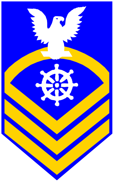 The image shows a stylized emblem with an eagle on top of what appears to be a shield-like design featuring nautical elements such as anchors and ropes; below this is another symbol that looks like a compass rose, which suggests maritime or navigation themes.