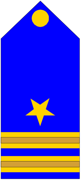 The image shows a blue flag with yellow stars on it hanging from an unseen pole against a gray background.
