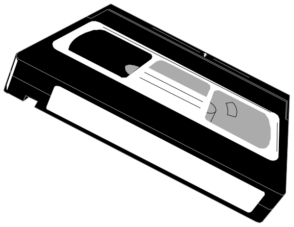 The black and white photo shows a cassette tape with its label facing upwards on what appears to be an electronic device that resembles a VCR player.