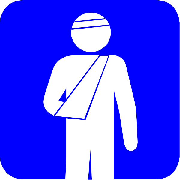 The image shows a blue sign with white text that reads "First Aid" on it next to an icon of a person in pain holding their arm while standing near another figure wearing what appears to be medical attire, possibly indicating first aid assistance is available here.
