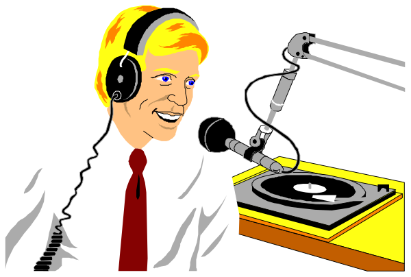 The image shows a man sitting at a radio station with headphones on his ears; he is smiling while looking towards something off-camera to his right.