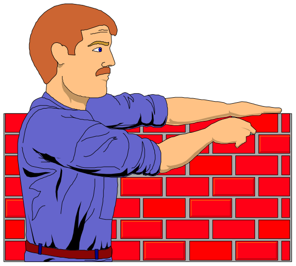 The image shows a man with red hair pointing to his right at something off screen while standing next to two brick walls; he is wearing blue jeans and has a mustache.