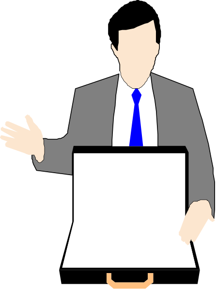 The image shows a man standing behind an easel with papers on it; he is gesturing towards something off-camera while wearing a suit jacket over his shoulder.