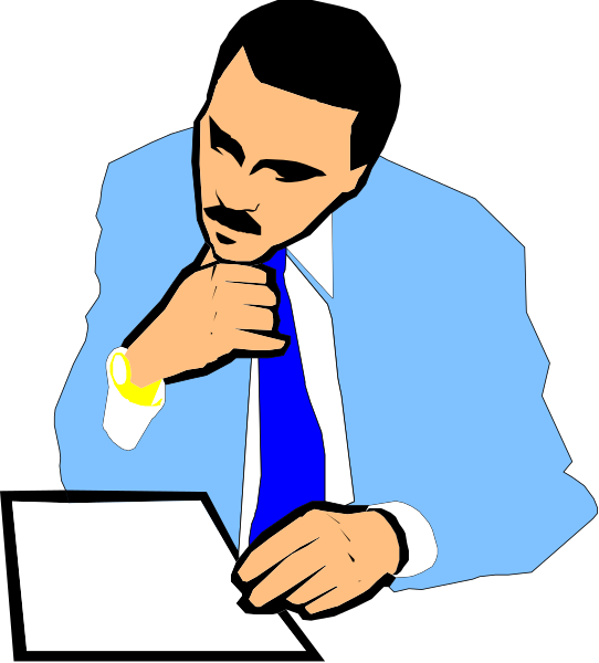 The image shows a man sitting at his desk with papers spread out before him; he is wearing a suit jacket over a blue shirt and has one hand on chin in thoughtful pose while looking downward towards some documents, possibly reviewing them for work purposes.