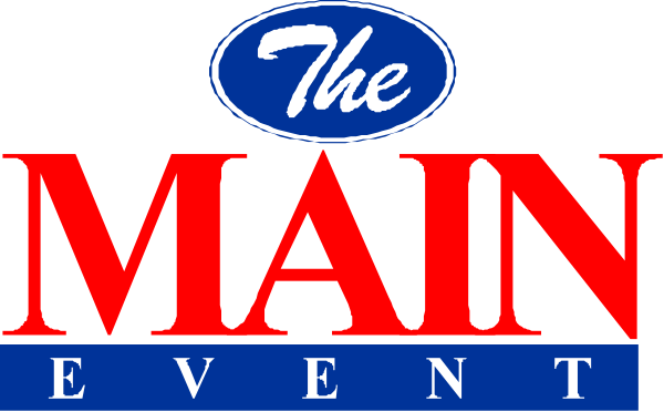 The logo of "The Main Event" with a blue background featuring white text is displayed on an event signage atop a stage during what appears to be a live performance or presentation.