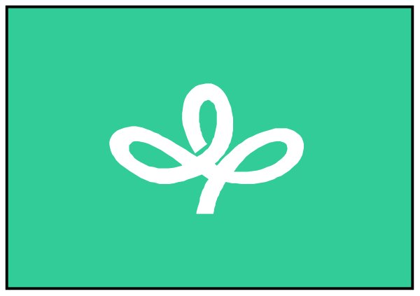 The image shows a green plant with white leaves on top of an open book that is lying flat against a gray background.