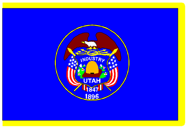 The image shows a blue banner with text that reads "UTAH INDUSTRY 1896" on it, indicating an event related to Utah's industry history from over one hundred years ago. There is also a small American flag in the top right corner of the banner and some decorative elements around its border. The background behind this blue banner appears grayish-blue with no distinct features or objects present that can be confidently described without more context about what's beyond it.