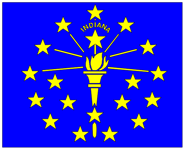 The flag of Indiana with a torch on it flying over an American cityscape at nighttime under clear skies.