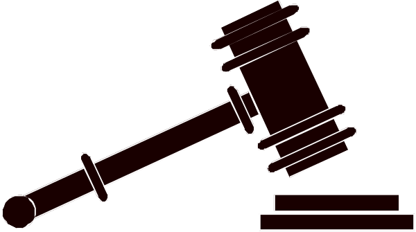 The image shows a gavel with an attached scale on top of it next to what appears to be a podium base.