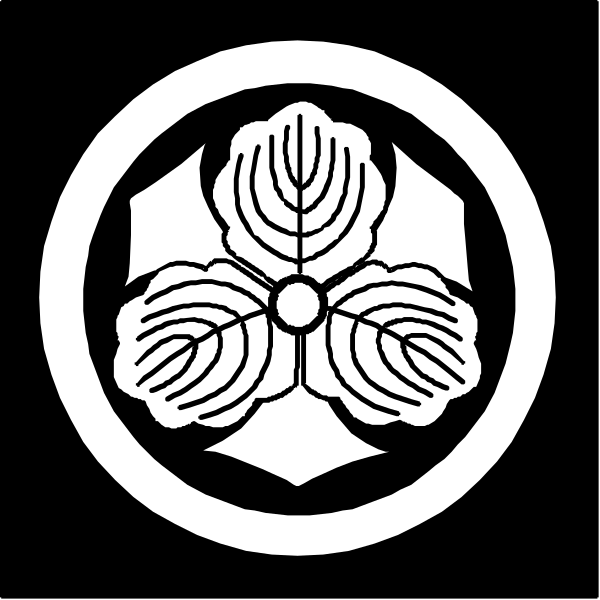 The logo features a stylized emblem with an open book design at its center, surrounded by two symmetrical leaves on either side of what appears to be a shield-like shape in black coloring against a white background within a circular border that has Japanese characters around it.