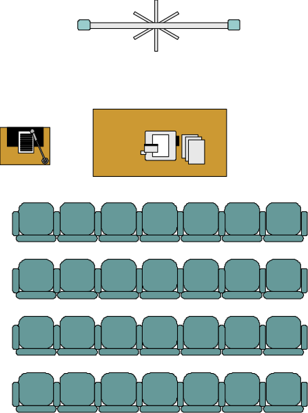 The image shows a black and white representation of an auditorium with rows of seats on either side leading to a stage in front where there is one person sitting at a desk under what appears to be a spotlight, suggesting that this could represent a presentation setup or event venue.