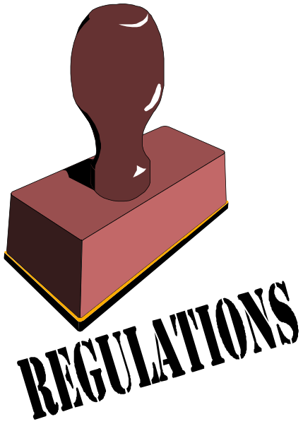 The image shows a red brick with an engraved pattern on it placed next to a black object that resembles a keyhole cover in front of what appears to be a dark background.