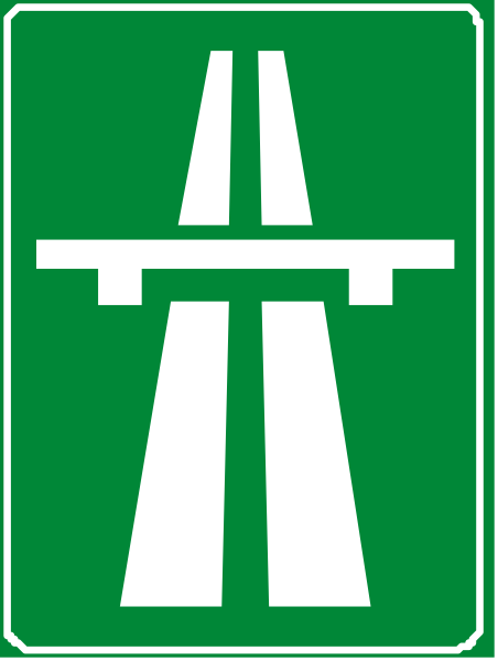 The image shows a green highway sign with white lines indicating lanes on either side of an interstate roadway.