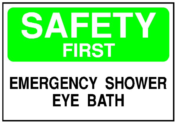 The image shows a sign with text that reads "SAFETY FIRST" at top followed by instructions for an emergency shower bath eye wash area below it.