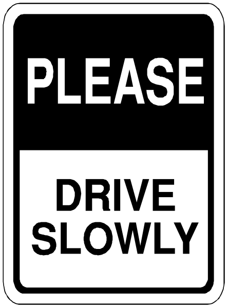 The sign says "please drive slowly." It's a black and white photo of an actual street sign with red lettering on it that is placed in front of some buildings.