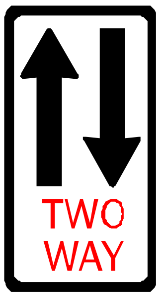 The image shows a black sign with white text that reads "TWO WAY" at its top right corner, indicating two arrows pointing in opposite directions to suggest traffic flow on both sides of an unseen roadway; below this is another arrow labeled as 'ONE WAY' and the word 'WAY'.
