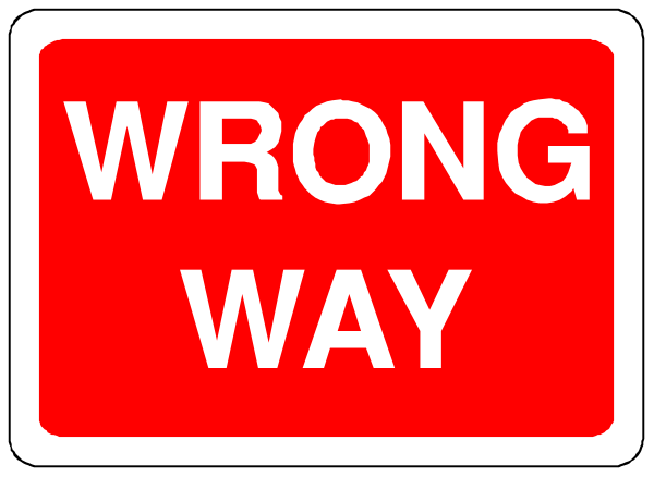 The image shows a red street sign with white text that reads "WRONG WAY" on top of another smaller rectangular sign below it labeled as "WROUGH ROAD."