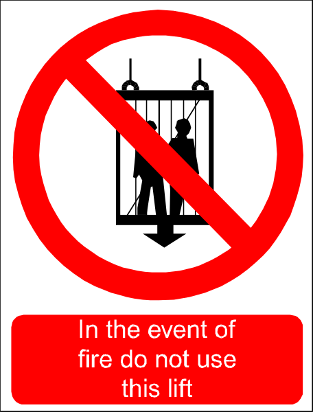 The sign displays a prohibition against using fire lifts with an illustration of two figures standing on such lift next to text that reads "in event of fire do not use this lift".