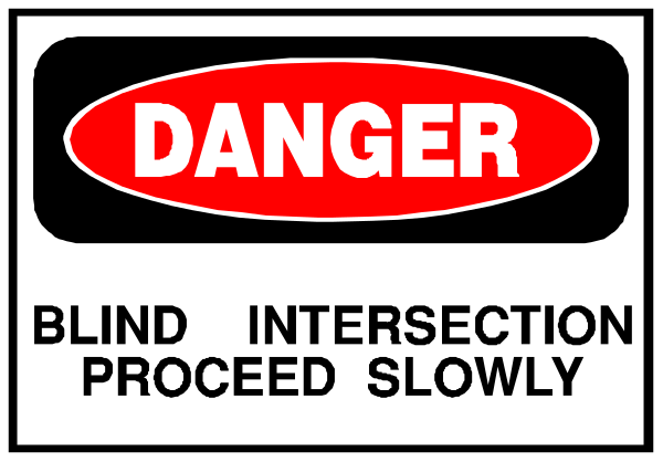 The image shows a sign with text that reads "DANGER" at top followed by instructions to proceed slowly while blindly crossing an intersection in slow motion.