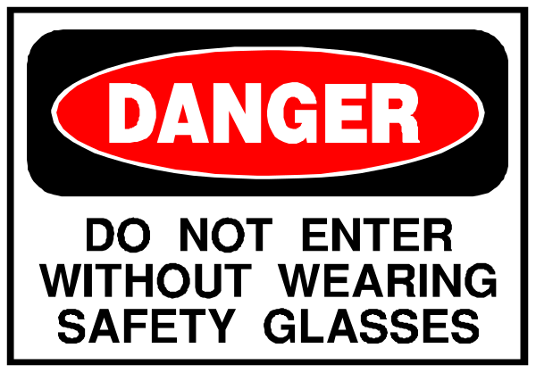 The image shows a sign with text that reads "DANGER DO NOT ENTER WITHOUT SAFETY GLASSES" in bold letters atop an exclamation mark symbolizing danger. Below this, there is additional smaller print stating "without wearing safety glasses."