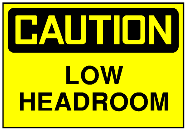 The image shows a yellow caution sign with black text that reads "CAUTION LOW HEADROOM" on top of another smaller white sign below it stating "LOW HEADROOM."