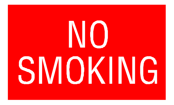 The image shows a red "no smoking" sign with white text on it against an indistinct background that appears to be grayish-brown in color.