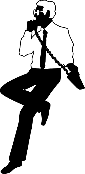 The black and white photo shows a man standing with his hands clasped together at chest level against an indistinct background that appears to be in motion due to blurring effect on right side of image.