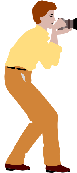 The image shows a man taking pictures with his camera while standing next to an orange wall.