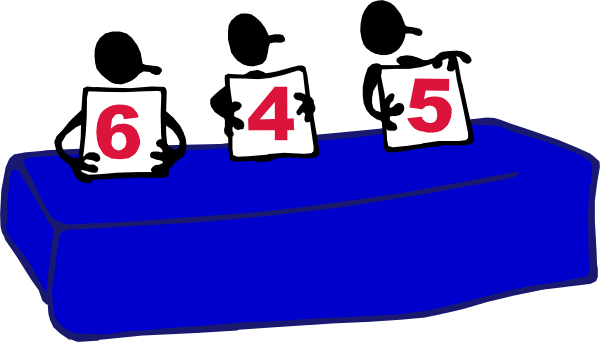 The image shows a table with three signs on it displaying numbers 6543210, each sign is placed above another in descending order of number size from left to right; there's no visible text other than these numerical values and their arrangement suggests they are part of an event or competition. There appears to be a blue tablecloth on the surface beneath them with some indistinct items that could possibly resemble signs, but it is not clear enough for me to describe accurately. The background behind this setup seems darkened which makes these objects stand out more promin
