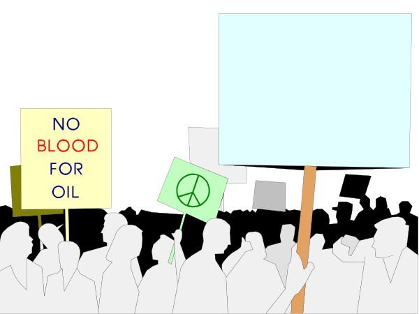 The image shows a protest scene with several signs held by individuals who appear to be participating in an event related to environmental issues such as "no blood for oil."