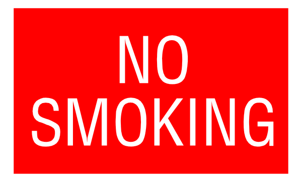 The image shows a red "no smoking" sign with white text on it against an indistinct background that appears to be dark grey in color.