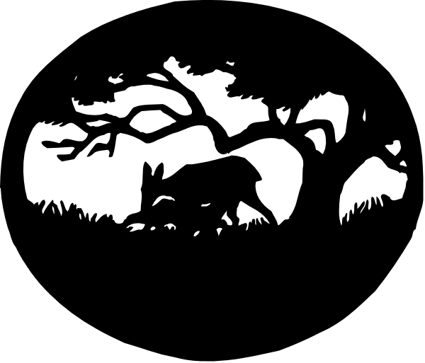 The black and white silhouette of a wolf standing under an old tree at night with its cubs nearby on what appears to be grassy ground in front of it.
