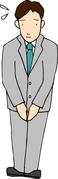 The image shows a man standing with his hands behind him against a dark background; he is wearing a suit jacket over what appears to be a blue shirt and tie, has short hair, and looks slightly surprised as indicated by raised eyebrows.