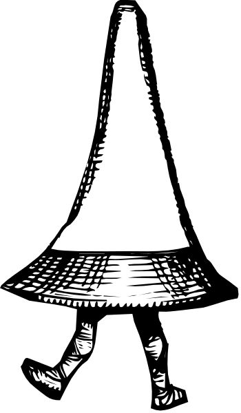 The black and white photo shows a person standing on stage with their back to us; we can see only from behind that it is an adult wearing what appears to be a cone-shaped hat atop its head, which obscures most of the face.